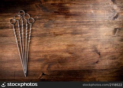 Skewers for kebab on the table. On a wooden background. High quality photo. Skewers for kebab on the table.