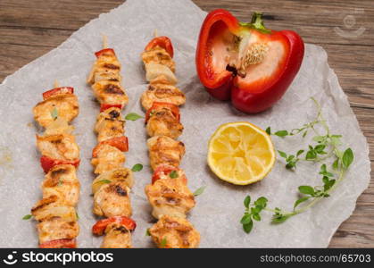 Skewers of grilled chicken satay with red peppers and onions with and sauteed carrots