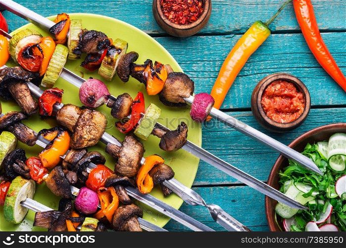 Skewers of grilled vegetables.Vegetable kebabs with peppers, mushrooms, zucchini and tomatoes. Grilled vegetables skewers kebab
