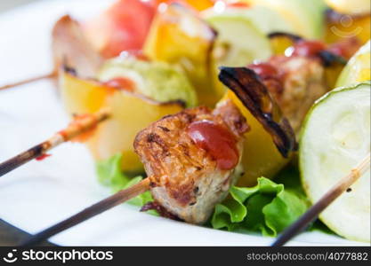 skewers of meat and various fresh vegetables