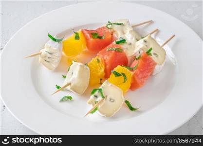 Skewers with cheese and trout on the white plate