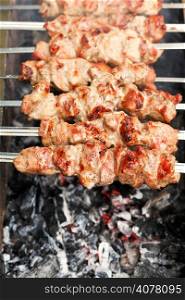 skewers with shish kebabs over burning coal close up