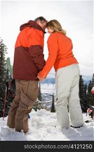 Ski Couple in Snow Holding Hands