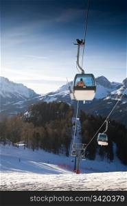 Ski lift cabins against clear blue sky. Italian Alps Resort.