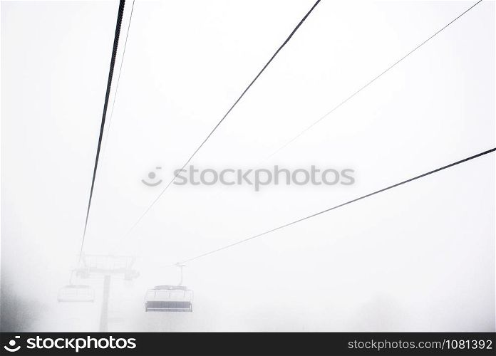 Ski lift in a dense morning fog