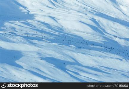 Ski lifts and skiers on winter snowy slope (Tyrol, Austria). All people are unrecognizable.