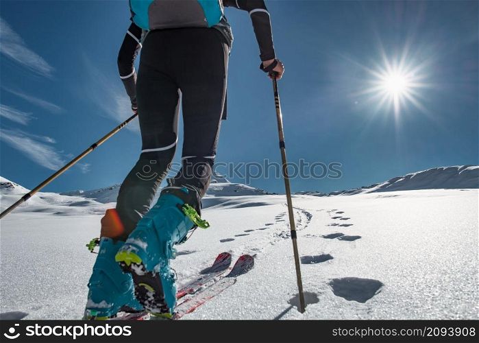 Ski mountaineer climbs up a snowy slope with seal-skins