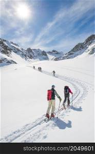 Ski mountaineering ascent track in swiss alps with people climbing