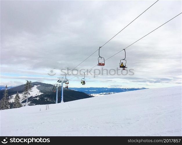 Ski resort, people on chairlift, snow mountain view in backgroun, Carpathin mountains, Dragobrat, Ukraine