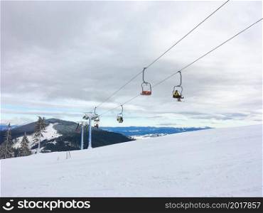 Ski resort, people on chairlift, snow mountain view in backgroun, Carpathin mountains, Dragobrat, Ukraine