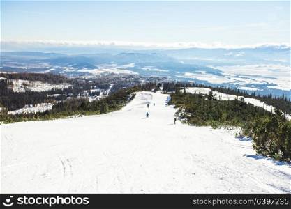 Ski slope in High Tatras mountains. Frosty sunny day. Ski slope and skier