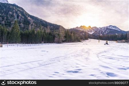 Ski slope in the Alps mountains - Winter scenery with a ski slope ready to be used, in the Austrian Alps mountains, on a sunny day of December.