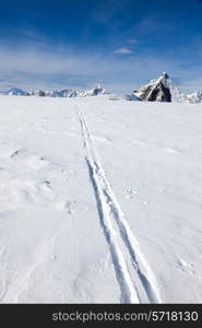 Ski track on fresh snow. Winter sport background with the famous Matterhorn peak - Zermatt ski resort, Switzerland, Europe.