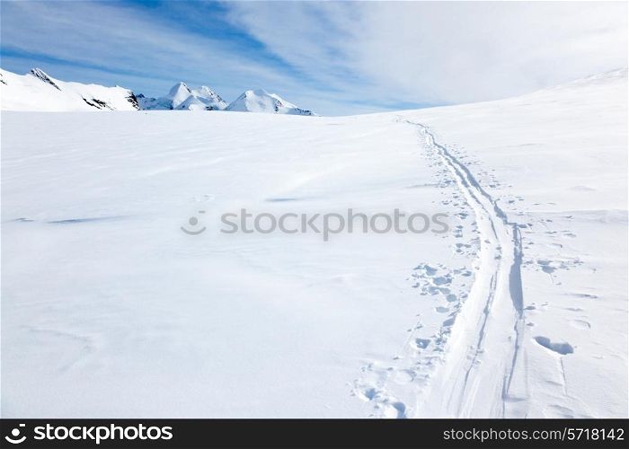 Ski tracks on the fresh snow of a large glacier. In background with the peaks of Monte Rosa massif - Zermatt, Switzerland, Europe.