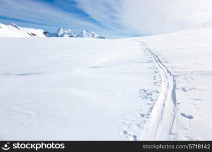 Ski tracks on the fresh snow of a large glacier. In background with the peaks of Monte Rosa massif - Zermatt, Switzerland, Europe.