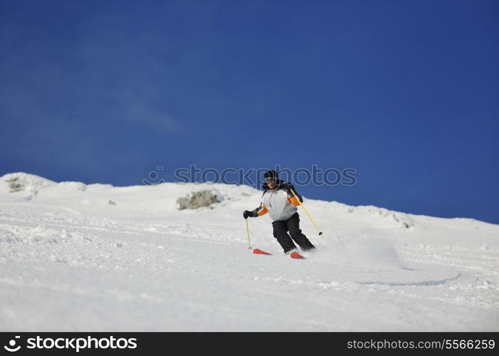 skier free ride downhill at winter season on beautiful sunny day