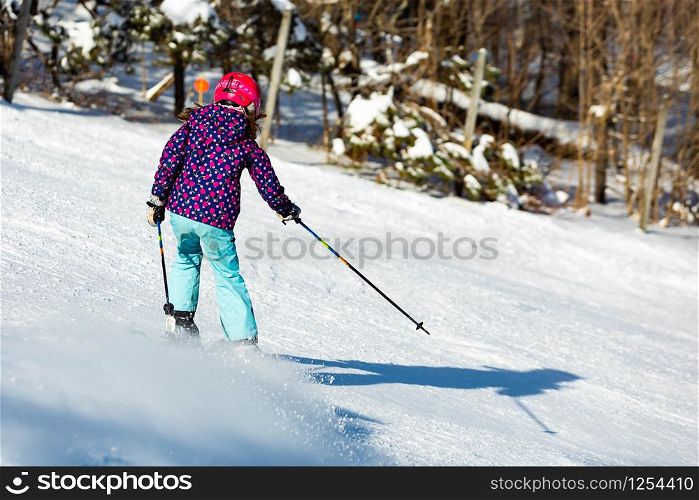 Skier girl performing slalom ride and having fun at resork in winter from the back isolated. Skier girl performing slalom ride and having fun at resork in winter from the back