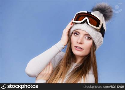 skier girl wearing warm clothes ski googles portrait. . Woman skier girl wearing warm clothing ski googles portrait. Winter sport activity. Beautiful sportswoman on blue studio shot