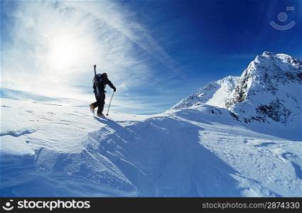 Skier hiking to mountain summit