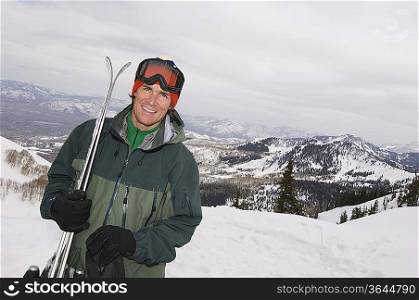 Skier Holding Skis on Mountain