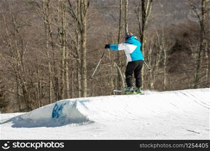 Skier jumping and having fun at resork in winter form the back in the air. Skier jumping and having fun at resork in winter form the back