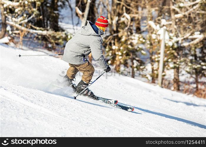 Skier performing slalom ride and having fun at resork in winter from the back isolated. Skier performing slalom ride and having fun at resork in winter from the back
