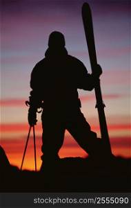 Skier standing outdoors at dusk (silhouette)