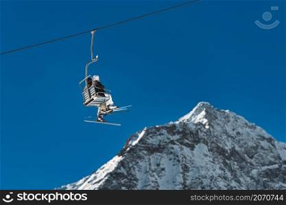 Skiers go up on the chairlift without cover
