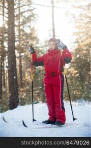 skiing in the forest. A little boy in red clothes is skiing in a pine forest