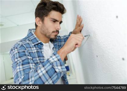 skilled electrician preparing holes before installing appliance