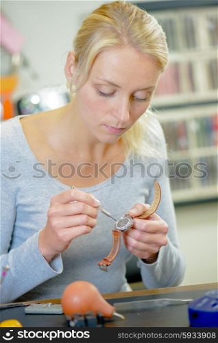Skilled woman repairing a watch