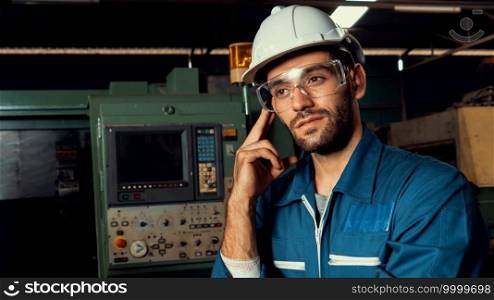 Skillful factory engineer or worker portrait while thinking and looking forward . Industrial people and manufacturing labor concept .. Skillful factory engineer or worker portrait while thinking and looking forward