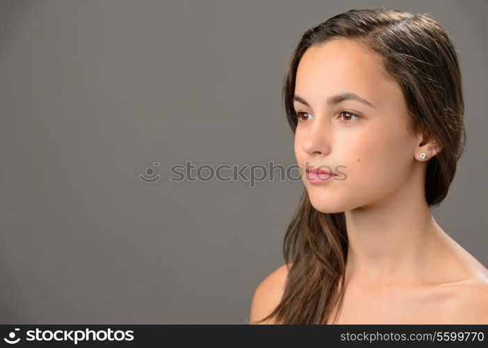 Skin beauty teenage girl brunette looking away on gray background