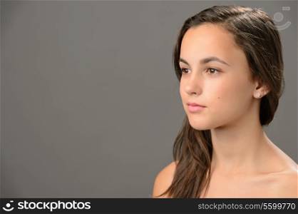 Skin beauty teenage girl brunette looking away on gray background
