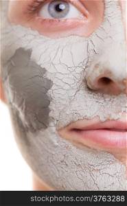 Skin care. Closeup of female face. Young woman applying clay mask. Girl taking care of her dry compexion. Isolated. Spa and beauty treatment.