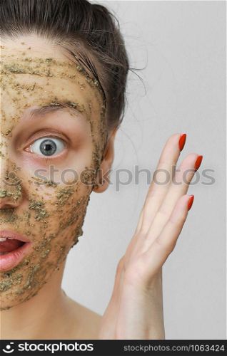 Skin Care. Cosmetic Day. young girl in home style, her hair gathered with her hands at the top. With eco, herbal, natural mask, green on the face. Skin Care. Cosmetic Day. young girl in home style, her hair gathered with her hands at the top. With eco, herbal, natural mask, green on the face. Front view.