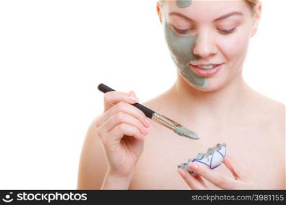 Skin care, cosmetology concept. Woman applying mud algae face mask with brush.. Woman applying face mask with brush