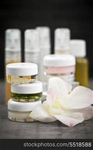 Skin care products. Various jars and bottles of skin care products with orchid flower