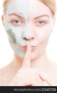 Skin care, secrets, cosmetology concept. Woman having mud algae mask on her face, making silence gesture. Woman having mud green mask on her face