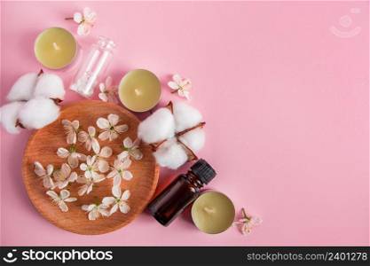Skin care, spa and aromatherapy concept. Natural cosmetic products on a pink background. Aroma candles and flowers for relaxation and yoga. Place for your text.. Skin care, spa and aromatherapy concept. Natural cosmetic products on a pink background. Aroma candles and flowers for relaxation and yoga.