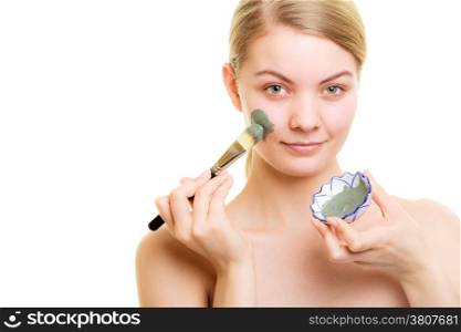 Skin care. Woman applying with brush clay mud mask on face isolated. Girl taking care of dry complexion. Beauty treatment.