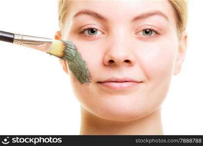 Skin care. Woman applying with brush clay mud mask on face isolated. Girl taking care of dry complexion. Beauty treatment.