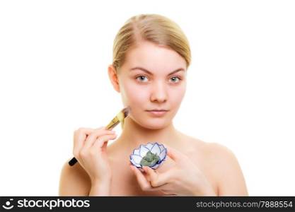 Skin care. Woman applying with brush clay mud mask on face isolated on white. Girl taking care of dry complexion. Beauty treatment.