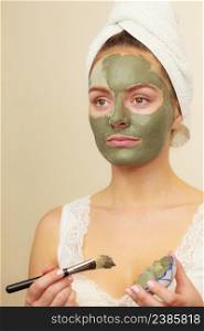 Skin care. Woman applying with brush clay mud mask to her face. Girl taking care of oily complexion. Beauty treatment.. Woman applying with brush clay mud mask to her face