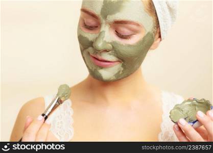Skin care. Woman applying with brush clay mud mask to her face. Girl taking care of oily complexion. Beauty treatment.. Woman applying with brush clay mud mask to her face