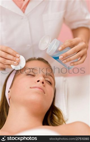 Skin care - woman cleaning face by beautician