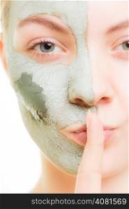 Skin care. Woman in clay mud mask on face with finger on lips isolated on white. Girl taking care of dry complexion. Secret of beauty.