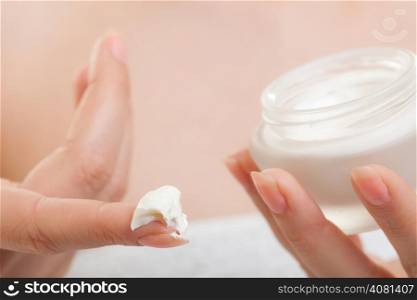 Skincare. Closeup of cosmetic. Young woman girl taking care of her dry complexion applying moisturizing cream isolated. Beauty treatment.