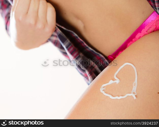 Skincare. Closeup of female body with heart shaped cream. Young woman girl taking care of her dry legs skin applying moisturizer lotion. Beauty treatment.