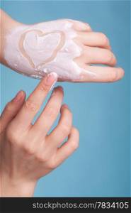 Skincare. Closeup of female hands with heart love symbol. Young woman girl taking care of her dry hands palms applying moisturizing cream. Beauty treatment.